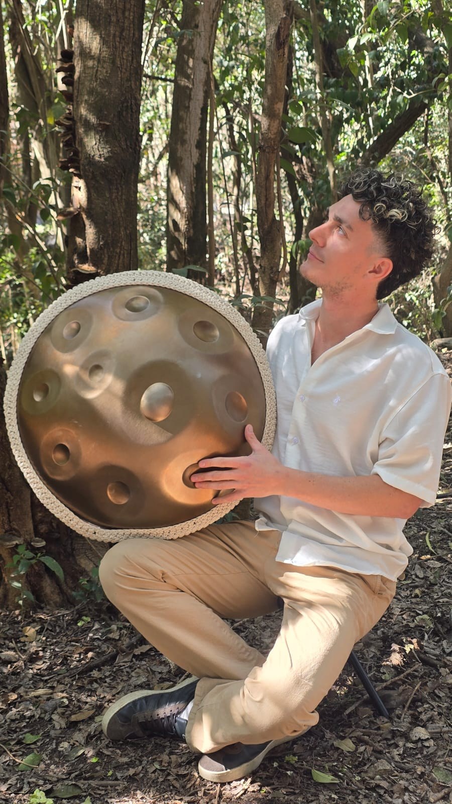 Facundo Cipriani Bayard con su handpan, mirando hacia el cielo